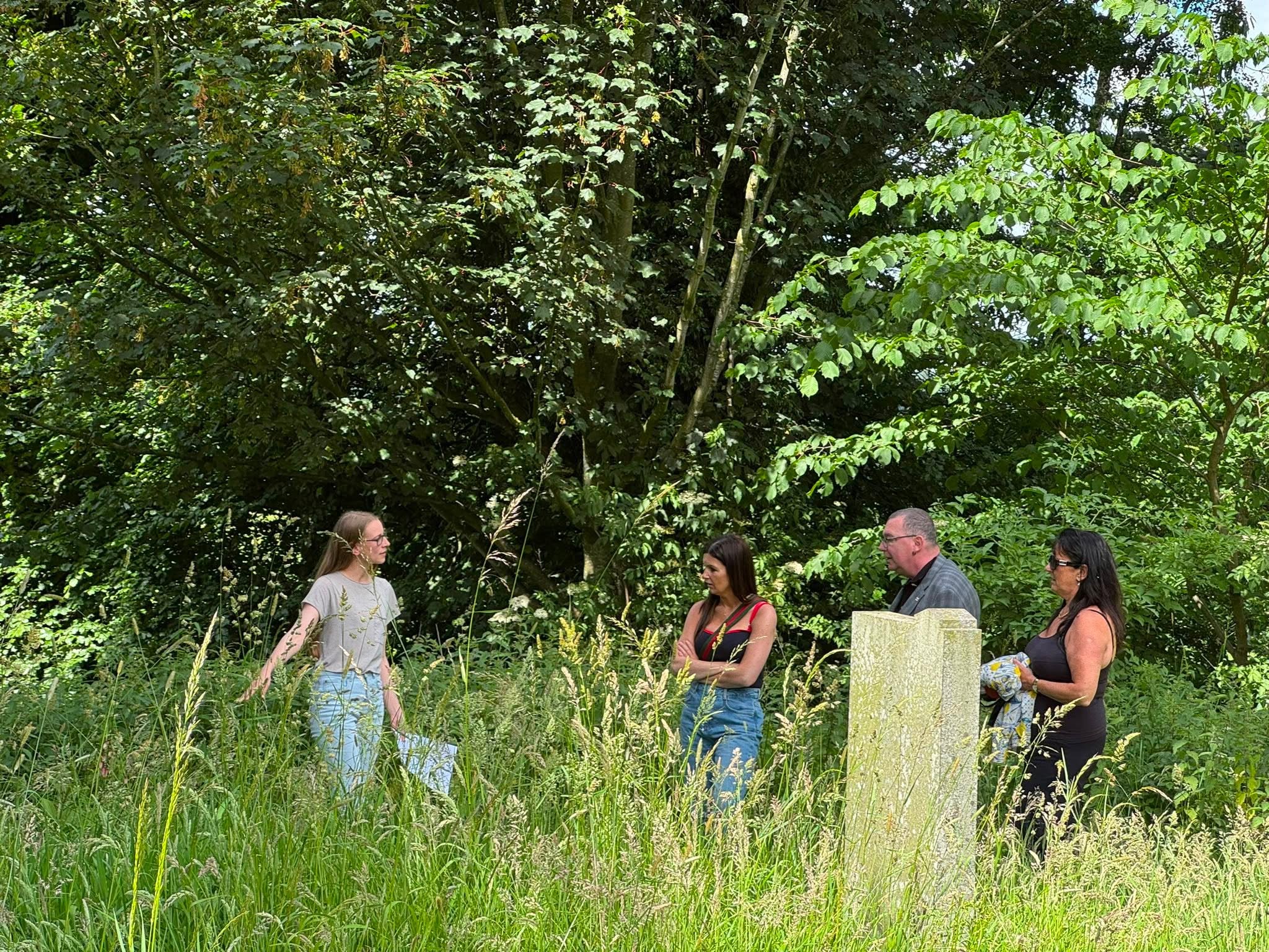 Brittany Warren speaking to visitors beside a gravestone at Brampton Old Church
